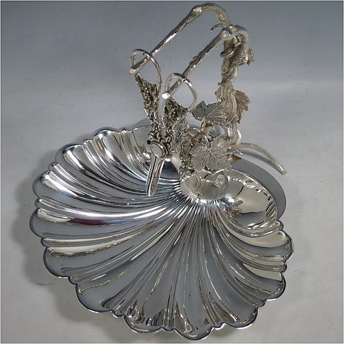 An Antique Victorian silver-plated grape dish stand with a pair of original grape shears in the Grapevine pattern, with cast vine-leaf tendrils, and a shell-style dish, sitting on three ball feet. All made by William Hutton & Sons of Sheffield in ca. 1880. The dimensions of this fine hand-made antique silver plated grape dish stand and scissors are height 27 cms (10.5 inches), width 25.5 cms (10 inches), and length 25.5 cms (10 inches).   