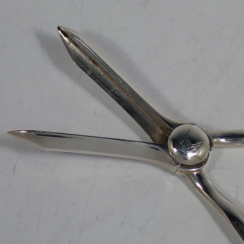 A very handsome Antique Edwardian Sterling Silver pair of grape shears or scissors in the single-struck hollow-ribbed Rattail pattern. Made by Elkington and Co., of Birmingham in 1909. The dimensions of this fine hand-made pair of antique silver grape scissors or shears are length 18 cms (7 inches), and they weigh approx. 115g (3.7 troy ounces).    