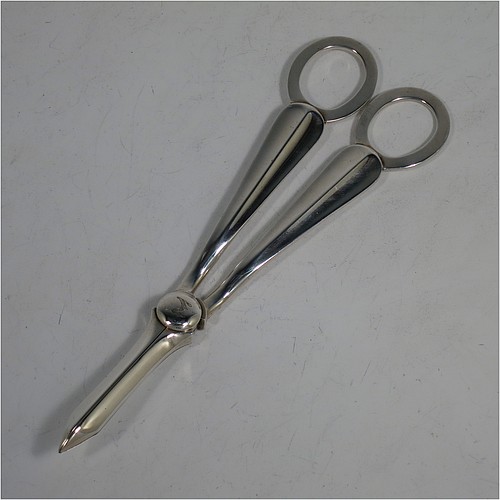 A very handsome Antique Edwardian Sterling Silver pair of grape shears or scissors in the single-struck hollow-ribbed Rattail pattern. Made by Elkington and Co., of Birmingham in 1909. The dimensions of this fine hand-made pair of antique silver grape scissors or shears are length 18 cms (7 inches), and they weigh approx. 115g (3.7 troy ounces).    