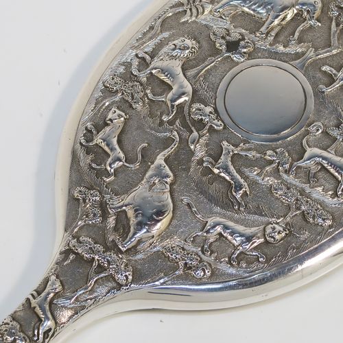 A beautiful Antique Victorian Indian Sterling Silver hand-mirror, having an oval body with a hand-chased scene of animals including lions, deer, dogs, leopards, and elephants, surrounding a central vacant round  cartouche, and an oval mounted mirror in a plain frame. This fantastic silver hand mirror was probably made for the Indian market in ca. 1880. The dimensions of this fine hand-made silver hand mirror are length 28 cms (11 inches), and width of main body 11 cms (4.3 inches).   