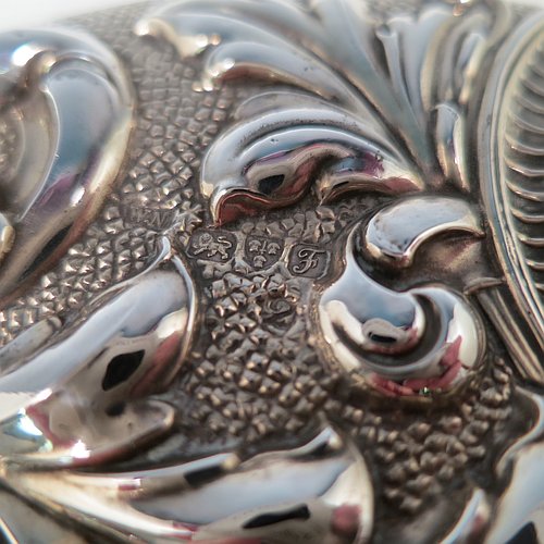 An Antique Edwardian Sterling Silver hand-mirror, having a round body with hand-chased floral decoration, a central vacant cartouche on the main body and an oval cartouche on the handle, and a round mirror. Made by William Neale of Chester in 1906. The dimensions of this fine hand-made antique silver hand mirror are length 28 cms (11 inches), and diameter 15 cms (6 inches).   