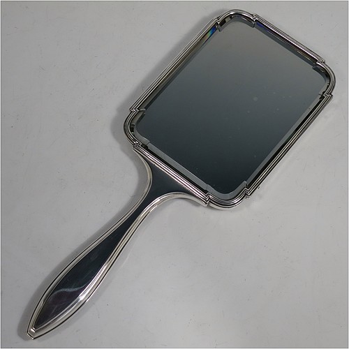 An Antique Sterling Silver and Tortoise-shell hand-mirror, having a rectangular body with shaped corners and reeded borders, a very pretty back with Neoclassical style inlaid tortoiseshell decoration, and an original bevelled mirror. Made in London in 1912. The dimensions of this fine hand-made antique silver and tortoise-shell hand mirror are length 30.5 cms (12 inches), and width of mirror 11 cms (4.25 inches).    