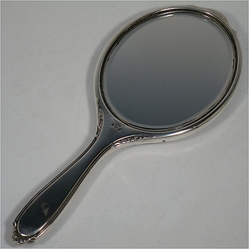 A Sterling Silver and Tortoise-shell hand-mirror, having an oval body with an applied floral border, with very pretty Neoclassical style inlaid tortoiseshell decoration, and an original bevelled mirror. Made by Mappin and Webb of Birmingham in 1928. The dimensions of this fine hand-made silver and tortoise-shell hand mirror are length 28 cms (11 inches), and width of mirror 11 cms (4.25 inches).    