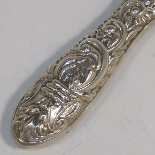 A very pretty Sterling Silver hand-mirror, having a round body with hand-chased floral and scroll decoration surrounding a central vacant cartouche, and a round bevelled mirror with rope-twist border. This beautiful silver hand mirror was made in Birmingham in 1982. The dimensions of this fine hand-made silver hand mirror are length 23.5 cms (9.25 inches), and diameter of main body 12.5 cms (5 inches).  