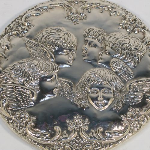 A very pretty Sterling Silver hand-mirror, having a round body with hand-chased floral border surrounding a group of winged cherub faces, and a round bevelled mirror with rope-twist border. This beautiful silver hand mirror was made in Birmingham in 1981. The dimensions of this fine hand-made silver hand mirror are length 23.5 cms (9.25 inches), and diameter of main body 12.5 cms (5 inches).