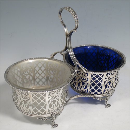 An Antique Edwardian Sterling Silver preserve, jam and honey pot holder, having a blue and frosted glass pot, sitting in a hand-pierced frame with floral and geometric decoration, with applied gadroon borders, a reeded and pierced loop handle, and all sitting on four cast floral feet. Made by Mappin and Webb of London in 1907. The dimensions of this fine hand-made antique silver and glass preserve holder are length 21 cms (8.25 inches), width 11 cms (4.25 inches), height 17.5 cms (7 inches),  and it weighs approx. 243g (7.8 troy ounces).   