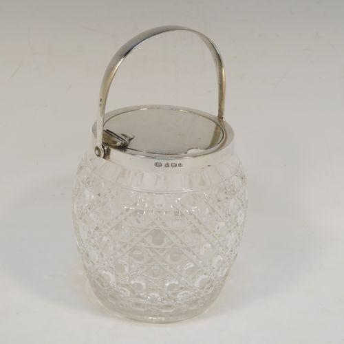 A very handsome and large Antique Sterling Silver and crystal honey or jam jar, having a hobnail cut round crystal body with a star-cut base, and a plain round mount with a mechanical swing-handled hinged lid. This beautiful antique silver jam or honey jar was made by Hukin and Heath of Birmingham in 1913. The dimensions of this fine hand-made antique silver and crystal jam or honey jar are height (inc. handle) 17 cms (6.75 inches), and diameter 11 cms (4.25 inches).