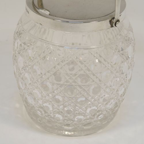 A very handsome and large Antique Sterling Silver and crystal honey or jam jar, having a hobnail cut round crystal body with a star-cut base, and a plain round mount with a mechanical swing-handled hinged lid. This beautiful antique silver jam or honey jar was made by Hukin and Heath of Birmingham in 1913. The dimensions of this fine hand-made antique silver and crystal jam or honey jar are height (inc. handle) 17 cms (6.75 inches), and diameter 11 cms (4.25 inches).