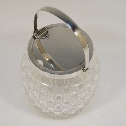 A very handsome and large Antique Sterling Silver and crystal honey or jam jar, having a hobnail cut round crystal body with a star-cut base, and a plain round mount with a mechanical swing-handled hinged lid. This beautiful antique silver jam or honey jar was made by Hukin and Heath of Birmingham in 1913. The dimensions of this fine hand-made antique silver and crystal jam or honey jar are height (inc. handle) 17 cms (6.75 inches), and diameter 11 cms (4.25 inches).