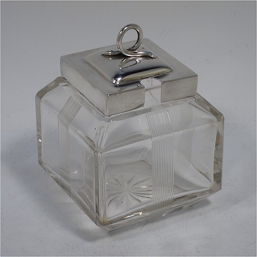 A very pretty Antique Edwardian sterling silver and hand-cut crystal jam, honey, or preserve jar, having a square body decorated with hand-engraved reeded vertical bands, and with sloping upper and lower borders, together with a square stepped pull-off silver lid with looped handle, and all sitting on a star-cut base. Made by Heath & Middleton of Birmingham in 1908. The dimensions of this fine hand-made antique silver and crystal jam or honey jar are height 9.5 cms (3.75 inches), and 7 cms (2.75 inches) square.   