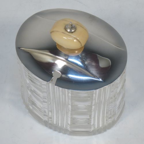 An elegant and stylish Art Deco Sterling Silver and hand-cut crystal jam, honey, or preserve jar, having a plain oval pull-off lid with matching bone finial and a slot for a spoon, and a hand-cut crystal body with reeded decoration and flat base. Made by Frank Cobb of Sheffield in 1936. The dimensions of this fine hand-made Art Deco silver and crystal jar are height 10 cms (4 inches), width 8 cms (3.25 inches), and depth 6.5 cms (2.5 inches)..  