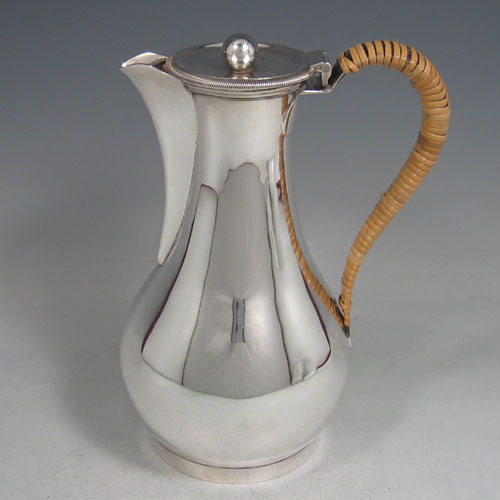    Antique Edwardian sterling silver hot water pot with wicker-work insulated handle, made by William Comyns of London in 1904. Height 21 cms.