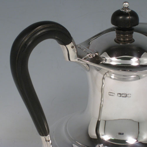 Antique Edwardian sterling silver hot water / milk pot, having a plain round baluster body, reeded borders, ebonised wooden scroll handle and finial, hinged lid, and sitting on a pedestal foot. Made by Henry Atkins of Sheffield in 1909. The dimensions of this fine hand-made silver serving pot are height 19 cms (7.5 inches), length 15 cms (6 inches), and it weighs approx. 400g (13 troy ounces).  