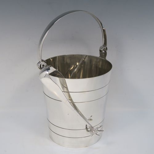 A very stylish Art Deco Silver Plated ice bucket, having a plain round body with tapering straight sides and hand-chased reeded decoration, an internal removable dry ice drainer, a pair of ice tongs, and with a hinged loop handle, and all sitting on a flat base. This elegant silver-plated ice bucket was made in ca. 1930. The dimensions of this fine hand-made silver-plated ice bucket are height (not including handle) 16 cms (6.3 inches), and diameter at lip 14.5 cms (5.75 inches).   