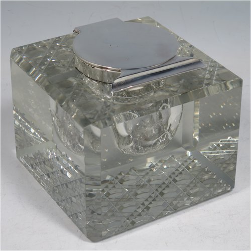 An Antique Edwardian Sterling Silver and hand-cut crystal inkstand, having a square body with chamfered corners, a plain round silver mount with a hinged lid and an unusual attached pen holder, and all sitting on a hand-cut hobnail pattern flat base. Made by Finnigans Ltd., of Birmingham in 1902. The dimensions of this fine hand-made antique silver and crystal inkstand are height 9 cms (3.5 inches), and 10 cms (4 inches) square.   