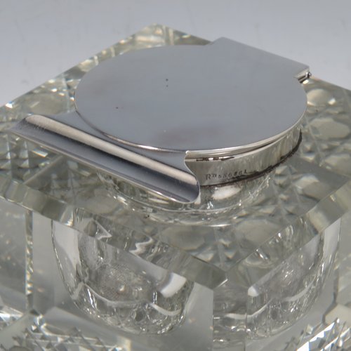 An Antique Edwardian Sterling Silver and hand-cut crystal inkstand, having a square body with chamfered corners, a plain round silver mount with a hinged lid and an unusual attached pen holder, and all sitting on a hand-cut hobnail pattern flat base. Made by Finnigans Ltd., of Birmingham in 1902. The dimensions of this fine hand-made antique silver and crystal inkstand are height 9 cms (3.5 inches), and 10 cms (4 inches) square.   