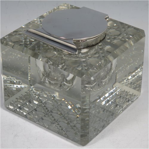 An Antique Edwardian Sterling Silver and hand-cut crystal inkstand, having a square body with chamfered corners, a plain round silver mount with a hinged lid and an unusual attached pen holder, and all sitting on a hand-cut hobnail pattern flat base. Made by Finnigans Ltd., of Birmingham in 1902. The dimensions of this fine hand-made antique silver and crystal inkstand are height 9 cms (3.5 inches), and 10 cms (4 inches) square.   