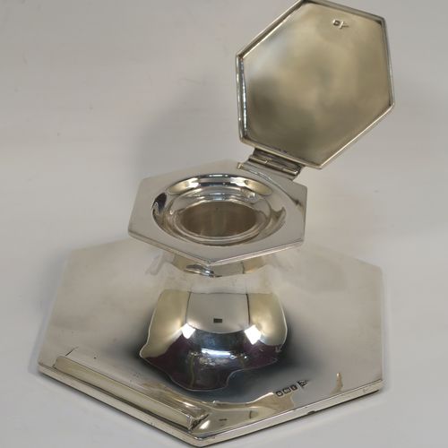 A handsome Antique Sterling Silver large Capstan inkwell, having a plain hexagonal body, with a hinged lid, a glass insert, and a front pen rest. This elegant antique silver inkwell was made by Walker and Hall of Sheffield in 1915. The dimensions of this fine hand-made antique silver capstan style inkwell are height 6 cms (2.3 inches), and width at widest point 15.5 cms (6 inches). Please note that the glass insert is slightly chipped on its upper edge.