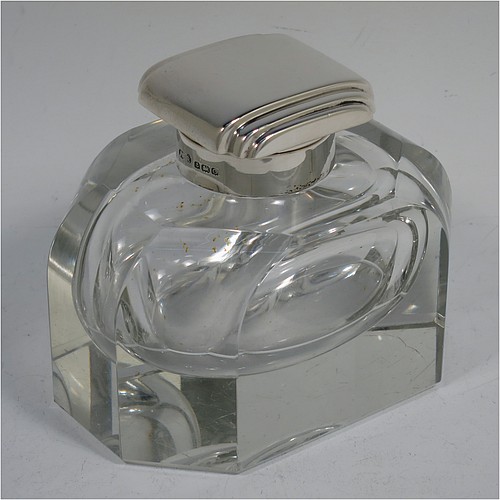 A very handsome Art Deco Sterling Silver and hand-cut crystal inkstand, having a rectangular body with rounded corners and panelled faces, a plain round silver mount with a square hinged lid having hand-chased stepped decoration, a removable small glass liner, and all sitting on a plain cut flat base. Made by the F. C. Richards of Birmingham in 1938. The dimensions of this fine hand-made silver and crystal inkstand are height 8.5 cms (3.25 inches), length 10 cms (4 inches), and width 7 cms (2.75 inches).    