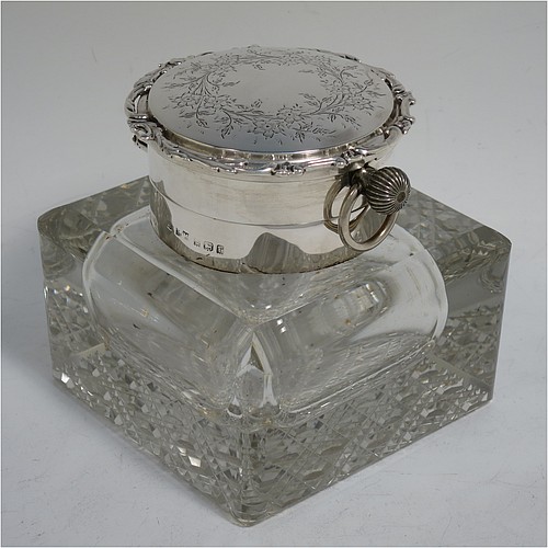 A very handsome and unusual Antique Edwardian Sterling Silver and hand-cut crystal combination inkstand paper weight and clock, having a square body with chamfered upper edges, a plain round mount and a domed hinged lid with hand-engraved floral decoration, the lid enclosing a very fine wind-up clock with black Roman numerals and a white face, all sitting on a flat base with a hand-cut hobnail pattern. Made by Henry Matthews of Birmingham in 1905. The dimensions of this fine antique silver and crystal combination inkstand and clock are height 10 cms (4 inches), and 10 cms (4 inches) square.   