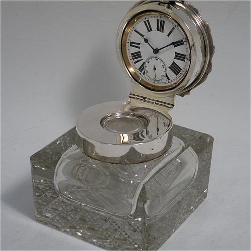 A very handsome and unusual Antique Edwardian Sterling Silver and hand-cut crystal combination inkstand paper weight and clock, having a square body with chamfered upper edges, a plain round mount and a domed hinged lid with hand-engraved floral decoration, the lid enclosing a very fine wind-up clock with black Roman numerals and a white face, all sitting on a flat base with a hand-cut hobnail pattern. Made by Henry Matthews of Birmingham in 1905. The dimensions of this fine antique silver and crystal combination inkstand and clock are height 10 cms (4 inches), and 10 cms (4 inches) square.   