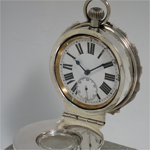 A very handsome and unusual Antique Edwardian Sterling Silver and hand-cut crystal combination inkstand paper weight and clock, having a square body with chamfered upper edges, a plain round mount and a domed hinged lid with hand-engraved floral decoration, the lid enclosing a very fine wind-up clock with black Roman numerals and a white face, all sitting on a flat base with a hand-cut hobnail pattern. Made by Henry Matthews of Birmingham in 1905. The dimensions of this fine antique silver and crystal combination inkstand and clock are height 10 cms (4 inches), and 10 cms (4 inches) square.   