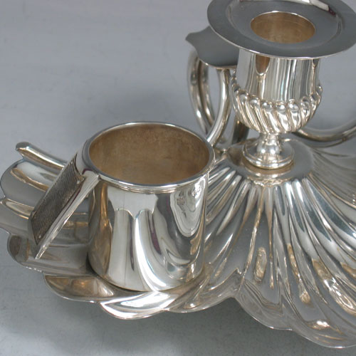 An Antique Victorian Sterling Silver very unusual inkstand, having a shell-style body with hand-chased scallop work, a central candle holder with removable nozzle, a match holder with strike plate, an ink bottle with hinged lid and removable glass liner, a looped carrying handle, and all sitting on three cast cushion feet. Made by Finley & Taylor of London in 1888. The dimensions of this fine hand-made antique inkstand are length 16.5 cms (6.5 inches), width 20 cms (8 inches), height 8.5 cms (3.3 inches), and it weighs approx. 427g (13.8 troy ounces).