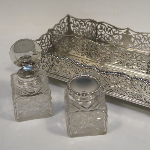 A very pretty Antique Victorian Sterling Silver gallery inkstand, having hand-pierced scroll and floral decoration, applied gadroon borders, two removable crystal inkwells with hinged lids, and all sitting on four cast foliate feet. This beautiful antique silver galleried inkstand was made by William J. Barnard of London in 1886. The dimensions of this fine hand-made silver inkstand are length 22 cms (8.75 inches), width 13 cms (5 inches), height 8 cms (3 inches), and it weighs approx. 620g (20 troy ounces).  