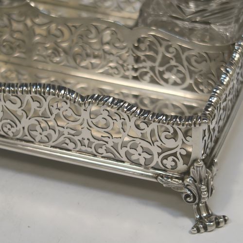 A very pretty Antique Victorian Sterling Silver gallery inkstand, having hand-pierced scroll and floral decoration, applied gadroon borders, two removable crystal inkwells with hinged lids, and all sitting on four cast foliate feet. This beautiful antique silver galleried inkstand was made by William J. Barnard of London in 1886. The dimensions of this fine hand-made silver inkstand are length 22 cms (8.75 inches), width 13 cms (5 inches), height 8 cms (3 inches), and it weighs approx. 620g (20 troy ounces).  