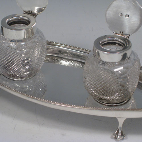    Antique Victorian sterling silver oval inkstand with two removable cut-crystal ink bottles. With bead edge, claw & ball feets, and hand-engraved decoration. Made by Martin & Hall of Sheffield in 1898. Length 24 cms (9.5 inches), width 9 cms (3.5 inches), height 8 cms (3 inches). 