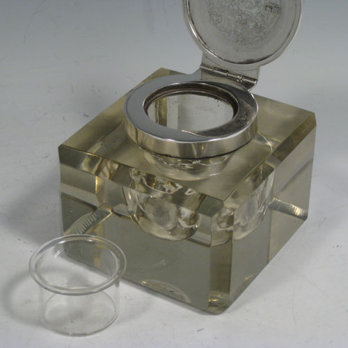 An Antique Victorian Sterling Silver and hand-cut crystal inkstand paper weight, having a square body with chamfered upper edges, a plain round mount and a flat-topped hinged lid, and with a removable glass liner, all sitting on a flat-cut plain base. Made by John Grinsell and Sons of London in 1898. The dimensions of this fine antique silver and crystal inkstand are height 7 cms (2.75 inches), and 9 cms (3.5 inches) square.