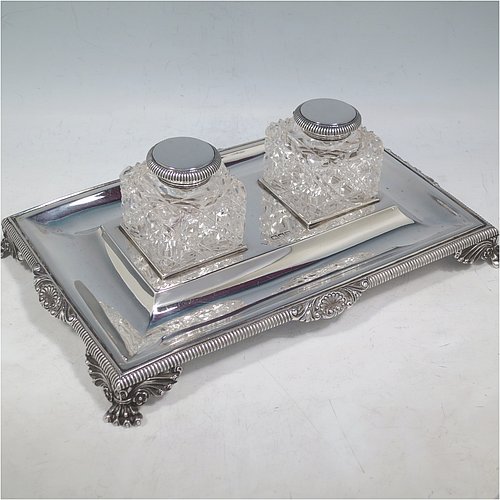 An Antique Victorian Sterling Silver inkstand, having a rectangular body with gadroon and shell border, two square hand-cut crystal removable ink bottles with round hinged lids, all sitting on four cast foliate and claw feet. Made by Henry Wilkinson & Co., of London in 1899. The dimensions of this fine hand-made antique silver double inkstand are length 25 cms (10 inches), width 16 cms (6.3 inches), height 8 cms (3.25 inches), and it weighs approx. 395g (12.6 troy ounces).