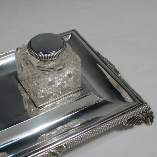 An Antique Victorian Sterling Silver inkstand, having a rectangular body with gadroon and shell border, two square hand-cut crystal removable ink bottles with round hinged lids, all sitting on four cast foliate and claw feet. Made by Henry Wilkinson & Co., of London in 1899. The dimensions of this fine hand-made antique silver double inkstand are length 25 cms (10 inches), width 16 cms (6.3 inches), height 8 cms (3.25 inches), and it weighs approx. 395g (12.6 troy ounces).