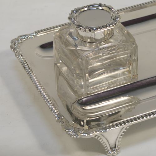 A very handsome Antique Victorian Sterling Silver double inkstand, having two inkwells with hand-cut crystal bodies and hinged lids, sitting on a stand with two pen-wells, and applied gadroon and shell borders, all sitting on cast flange feet. This beautiful antique silver inkstand was made by Charles Stuart Harris of London in 1901. The dimensions of this fine hand-made silver inkstand are height 8 cms (3 inches), length 23 cms (9 inches), width 16.5 cms (6.5 inches), and it weighs approx. 400g (13 troy ounces).   