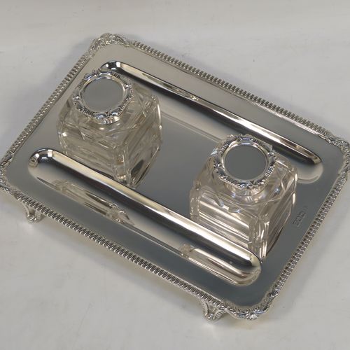 A very handsome Antique Victorian Sterling Silver double inkstand, having two inkwells with hand-cut crystal bodies and hinged lids, sitting on a stand with two pen-wells, and applied gadroon and shell borders, all sitting on cast flange feet. This beautiful antique silver inkstand was made by Charles Stuart Harris of London in 1901. The dimensions of this fine hand-made silver inkstand are height 8 cms (3 inches), length 23 cms (9 inches), width 16.5 cms (6.5 inches), and it weighs approx. 400g (13 troy ounces).   