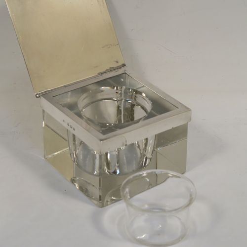 A very stylish Art Deco Sterling Silver and hand-cut crystal inkstand paper weight, having a square body, a plain square mount with a flat-topped hinged lid and engine-turned border, together with a removable glass liner, and all sitting on a flat-cut plain base. This handsome Art Deco inkstand was made by Deakin and Francis of Birmingham in 1933. The dimensions of this fine hand-made silver and crystal inkstand are height 5 cms (2 inches), and 7.5 cms (3 inches) square.   