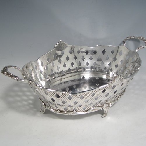 Antique Edwardian sterling silver jardinière, having an oval body with hand-pierced and engraved decoration in a basket-weave style, applied shell and scroll borders, with two cast floral handles, and sitting on four cast scroll feet. Made by Wakely & Wheeler of Chester in 1902. The dimensions of this fine hand-made silver table jardinière are length 35 cms (13.75 inches), width 20 cms (8 inches), height 11.5 cms (4.5 inches), and it weighs approx. 844g (27 troy ounces).  