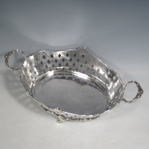 Antique Edwardian sterling silver jardinière, having an oval body with hand-pierced and engraved decoration in a basket-weave style, applied shell and scroll borders, with two cast floral handles, and sitting on four cast scroll feet. Made by Wakely & Wheeler of Chester in 1902. The dimensions of this fine hand-made silver table jardinière are length 35 cms (13.75 inches), width 20 cms (8 inches), height 11.5 cms (4.5 inches), and it weighs approx. 844g (27 troy ounces).  