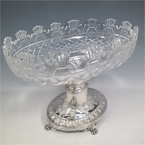 An Antique Victorian Sterling Silver jardinière / epergne, having an oval body with hand-cut crystal bowl, sitting on a cast and hand-chased stand with neoclassical style floral work, all standing on four cast lions-paw feet. Made by Henry Wilkinson of Birmingham in 1882. The dimensions of this fine hand-made antique silver and crystal jardinière / epergne are length 34 cms (13.5 inches), width 25 cms (10 inches), height 30.5 cms (12 inches), and it weighs approx. 1,118g (36 troy ounces).   