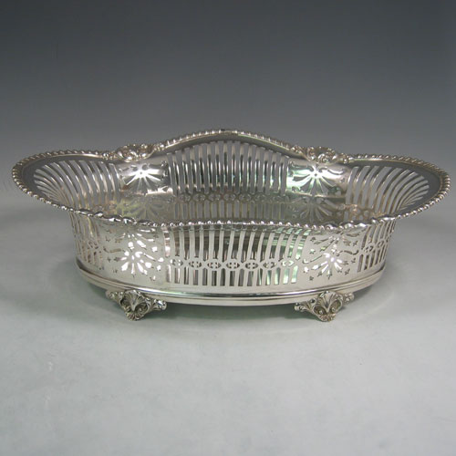 Antique Victorian silver (835 standard) jardinière, having an oval body, with hand-pierced geometrical and floral decoration, an applied shell and gadroon border, and sitting on four cast shell feet. Made in Austria (possibly) in ca. 1890. The dimensions of this fine hand-made jardinière are length 38 cms (16 inches), width 24 cms (9.5 inches), and height 13 cms (5 inches).