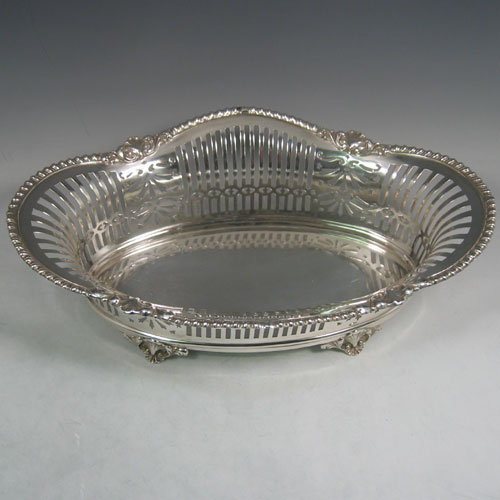 Antique Victorian silver (835 standard) jardinière, having an oval body, with hand-pierced geometrical and floral decoration, an applied shell and gadroon border, and sitting on four cast shell feet. Made in Austria (possibly) in ca. 1890. The dimensions of this fine hand-made jardinière are length 38 cms (16 inches), width 24 cms (9.5 inches), and height 13 cms (5 inches).