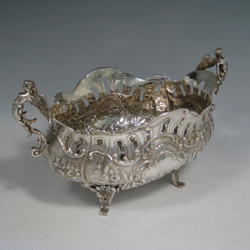 Antique Victorian sterling silver jardiniere, having an oval hand-chased and pierced body with floral decoration, two cast winged angel handles, sitting on four cast foliate feet. Probably Dutch in origin but with import assay marks for London in 1890. Length 28 cms (11 inches), width 15 cms (6 inches), height 16 cms (6.3 inches). Weight approx. 612g (19.7 troy ounces).