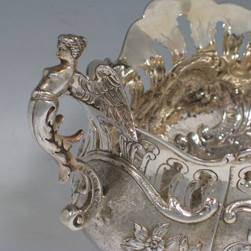 Antique Victorian sterling silver jardiniere, having an oval hand-chased and pierced body with floral decoration, two cast winged angel handles, sitting on four cast foliate feet. Probably Dutch in origin but with import assay marks for London in 1890. Length 28 cms (11 inches), width 15 cms (6 inches), height 16 cms (6.3 inches). Weight approx. 612g (19.7 troy ounces).