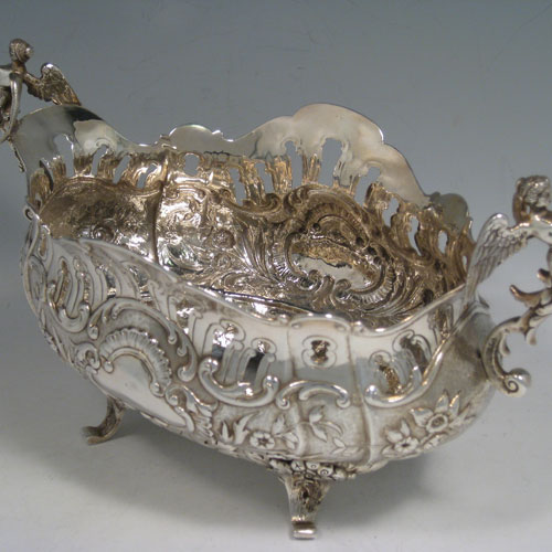 Antique Victorian sterling silver jardiniere, having an oval hand-chased and pierced body with floral decoration, two cast winged angel handles, sitting on four cast foliate feet. Probably Dutch in origin but with import assay marks for London in 1890. Length 28 cms (11 inches), width 15 cms (6 inches), height 16 cms (6.3 inches). Weight approx. 612g (19.7 troy ounces).