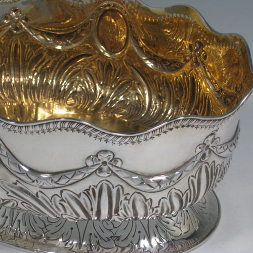 Antique Victorian sterling silver jardiniere, having a gold-gilt interior, applied shaped gadroon border, hand-chased oval body with anthemion leaf decoration and swags, sitting on a pedestal foot. Made by Charles Stuart Harris of London in 1887. Length 25 cms (10 inches), width 18 cms (7 inches), height 11 cms (4.25 inches). Weight approx. 612g (19.7 troy ounces).