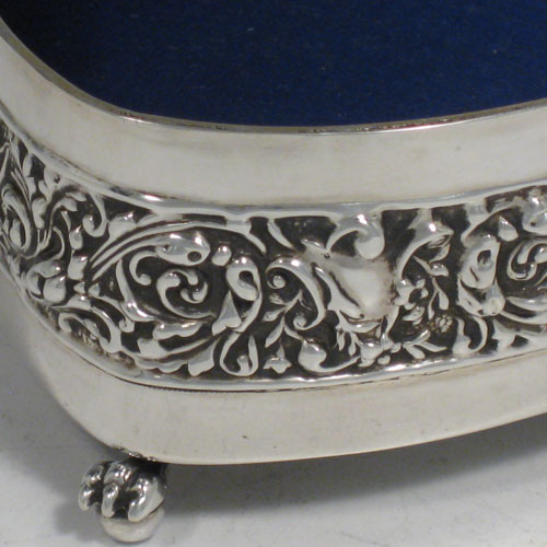    Antique Edwardian sterling silver Scottish jewelery box, having a heart-shaped body, with hand-chased floral sides, a hinged and pierced lid decorated with birds, cherubs, and flowers, all sitting on three cast claw and ball feet. Made by Hamilton and Inches of Edinburgh in 1907. Length 13 cms (5 inches), height 6 cms (2.3 inches). Weight approx. 290g (9.4 troy ounces).