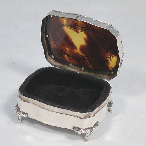 A very pretty Antique Edwardian Sterling Silver and tortoise-shell jewellery box, having a shaped rectangular body, a tortoise-shell hinged lid with in-laid flowers and ribbon bows, an applied gadroon border, a dark blue velvet-lined interior, and sitting on four cast foliate legs. Made by Henry Miller of Birmingham in 1910. The dimensions of this fine hand-made antique silver and tortoise-shell jewelery box are length 7 cms (2.75 inches), width 5.5 cms (2.25 inches), and height 3 cms (1.25 inches).   