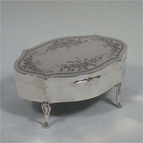 A very pretty Antique Sterling Silver jewelery box, having an oval-shaped body with straight sides, a flat hinged lid with hand-engraved floral decoration, a gold gilt and dark green velvet-lined interior, and all sitting on four cast foliate feet. Made by Henry Matthews of Birmingahm in 1912. The dimensions of this fine hand-made antique silver jewellery box are length 10cms (4 inches), width 7cms (2.75 inches), and height 5 cms (2 inches)    