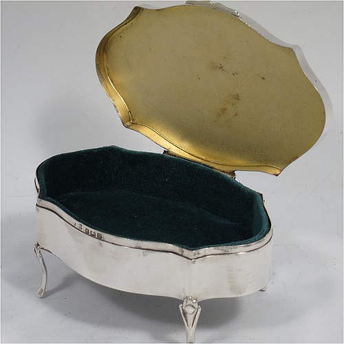 A very pretty Antique Sterling Silver jewelery box, having an oval-shaped body with straight sides, a flat hinged lid with hand-engraved floral decoration, a gold gilt and dark green velvet-lined interior, and all sitting on four cast foliate feet. Made by Henry Matthews of Birmingahm in 1912. The dimensions of this fine hand-made antique silver jewellery box are length 10cms (4 inches), width 7cms (2.75 inches), and height 5 cms (2 inches)    