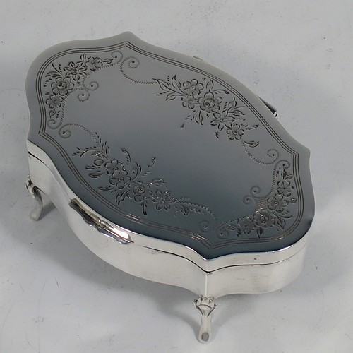 A very pretty Antique Sterling Silver jewelery box, having an oval-shaped body with straight sides, a flat hinged lid with hand-engraved floral decoration, a gold gilt and dark green velvet-lined interior, and all sitting on four cast foliate feet. Made by Henry Matthews of Birmingahm in 1912. The dimensions of this fine hand-made antique silver jewellery box are length 10cms (4 inches), width 7cms (2.75 inches), and height 5 cms (2 inches)    